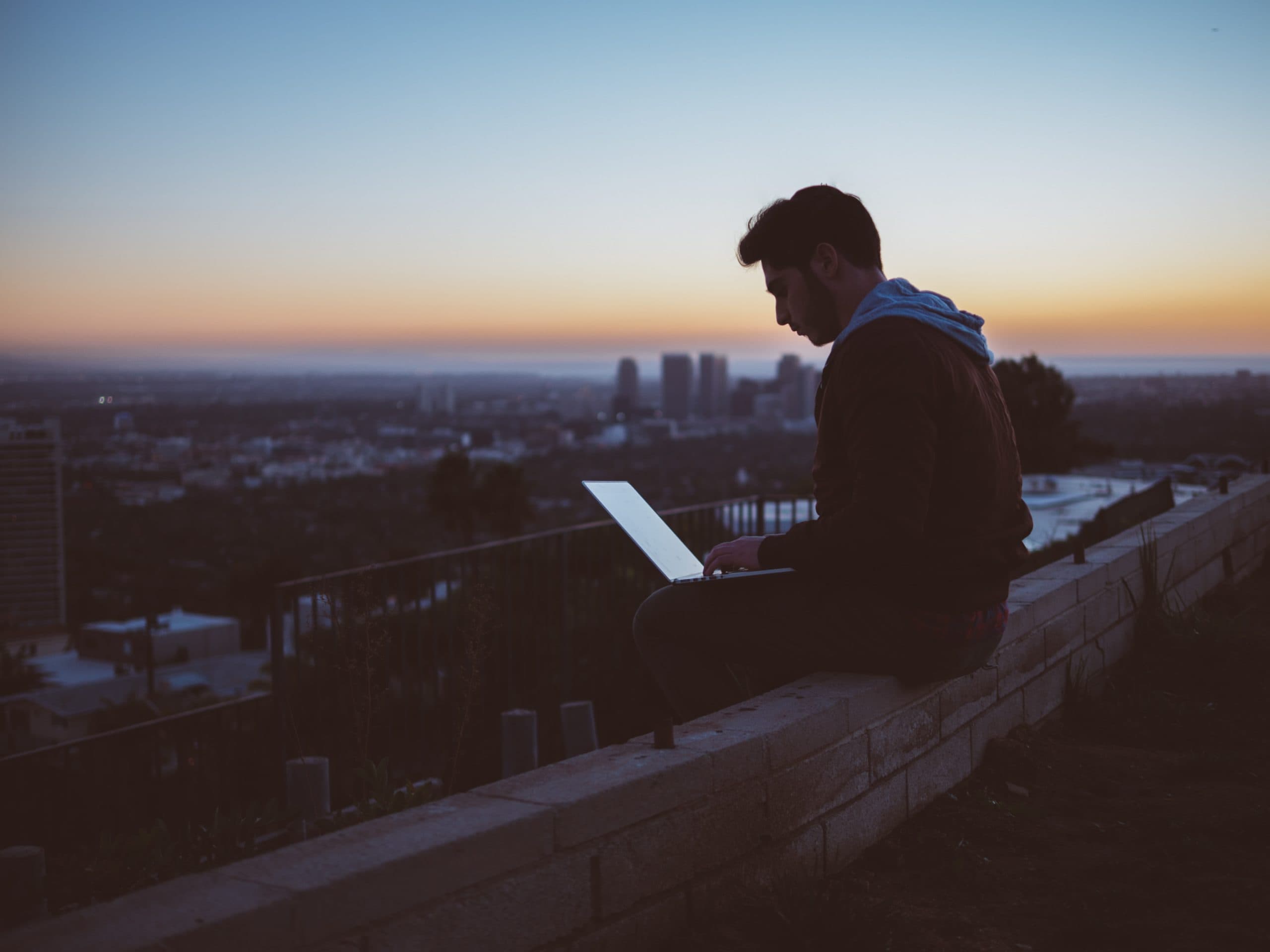 man working on laptop on wall